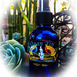 Pode incluir: Uma garrafa de vidro azul com um borrifador preto e um rótulo colorido que diz "Quan Yin Vibrant Synthesis vibrantsynthesis.org".