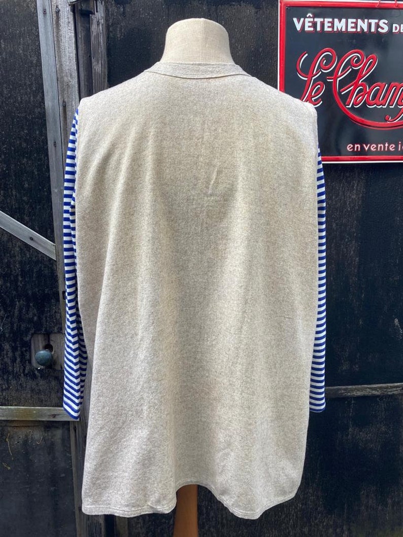 Puede incluir: Una camisa gris de manga larga con mangas a rayas azules y blancas. La camisa est&aacute; hecha de un material suave y c&oacute;modo.