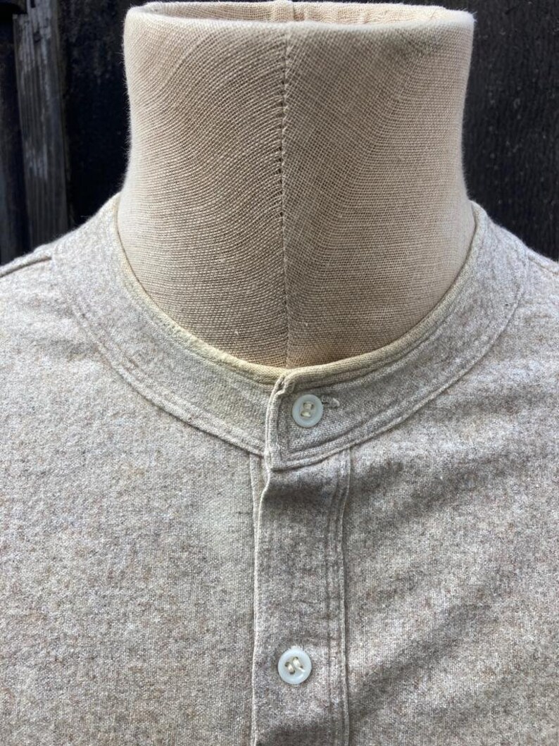 Puede incluir: Una camisa de manga larga de color marr&oacute;n claro con cuello mandar&iacute;n y cierre de botones en la parte delantera. La camisa est&aacute; hecha de una tela suave y texturizada.