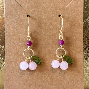 May include: A white ceramic mug with a black handle and the text "But First, Coffee" in a bold, black font. The mug is sitting on a wooden surface. The mug is 4 inches tall.