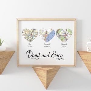 May include: A framed print with three heart-shaped maps representing "Met", "Engaged", and "Married" with corresponding dates. The names "Danil and Erica" are written in cursive below the maps.