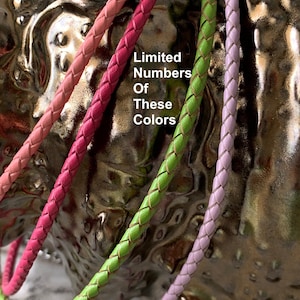 May include: Four braided leather cords in pink, red, green, and lavender. The cords are arranged in a circle and the text "Limited Numbers Of These Colors" is visible in the centre.
