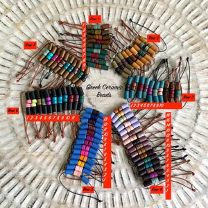 May include: Assortment of colorful ceramic beads arranged in rows on a light brown surface. Each row is numbered and labeled with the word "Row". The beads are various shapes and sizes, with some having a speckled or marbled appearance. The text "Greek Ceramic Beads" is written in the center of the image.