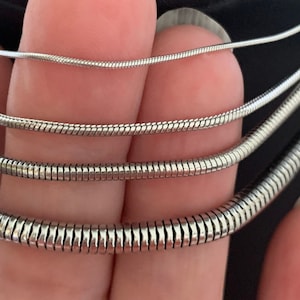 Closeup pictures of Snake Chain Necklace.  Gift for Christmas, Birthday, Anniversary Or other Holiday.  Snake Chain Necklace design in silver color made of 316L Stainless Steel.  No tarnishing.  Widths include 1mm, 1.5mm, 2.4mm and 4mm.