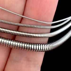 Close up of Silver Color Snake Chain Necklace. Snake Chain Necklace design in silver color made of 316L Stainless Steel.  Great wearing with no tarnishing. Nice for gift giving for Men or Women. Widths include 1mm, 1.5mm, 2.4mm and 4mm.