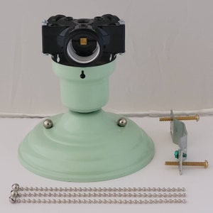 Könnte beinhalten: Ein hellgrünes Deckenventilator-Lichtset mit einer schwarzen Elektrodose, einer Metallhalterung und einer Kette mit silbernen Perlen.