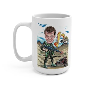 May include: White ceramic mug featuring a cartoon illustration of a man in military attire holding a rifle. The illustration includes a small vehicle and construction equipment on a desert-like background. The mug has a large handle.