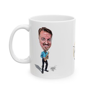 May include: White ceramic mug with a cartoon caricature of a man playing a saxophone. The man is wearing a blue shirt and black trousers. The mug has a white handle and a design on the right side.