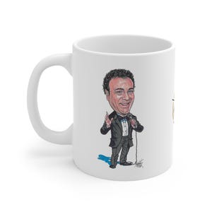 Puede incluir: Taza de cerámica blanca con una caricatura de un hombre con esmoquin sosteniendo un micrófono. La ilustración es en color e incluye una sombra azul. La taza tiene un asa curva y un acabado brillante.