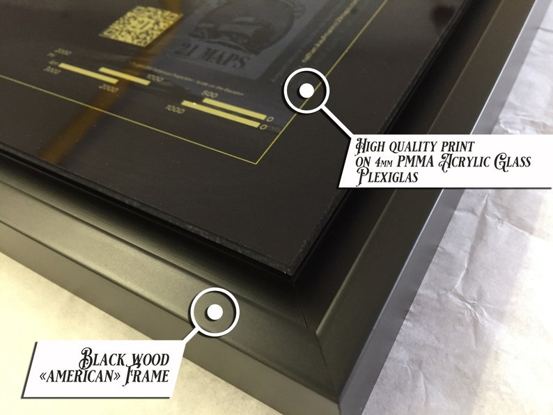 May include: A black wood frame with a black and gold print behind it. The print is on 4mm PMMA acrylic glass. The text on the print reads "21 MAPS".