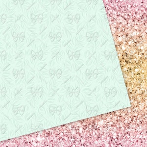 May include: A light blue background with a delicate white floral pattern. The background is cut diagonally to reveal a pink and gold glitter background.