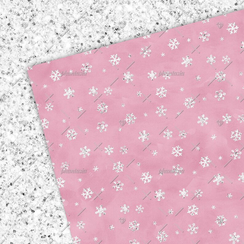 Pu&ograve; includere: Uno sfondo rosa con un motivo ripetitivo di fiocchi di neve bianchi. I fiocchi di neve hanno una texture scintillante.