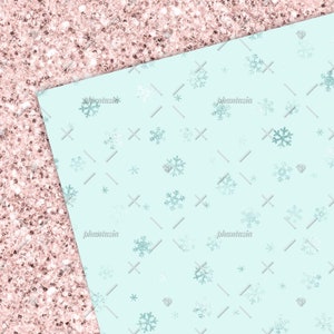 Peut inclure: Un fond bleu clair avec un motif de flocons de neige blancs. Le fond est divis&eacute; en diagonale avec une texture de paillettes roses.