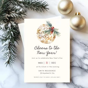 May include: New Year's Eve invitation card with a gold glitter ball illustration, text "Cheers to the New Year!", date, time, and address. The card is on a marble surface with pine branches and gold ornaments.