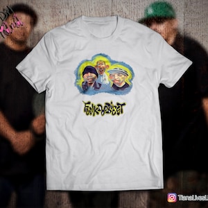May include: White t-shirt with a cartoon image of three men wearing hats and the text "Funk-o-Beat" in yellow and blue lettering.