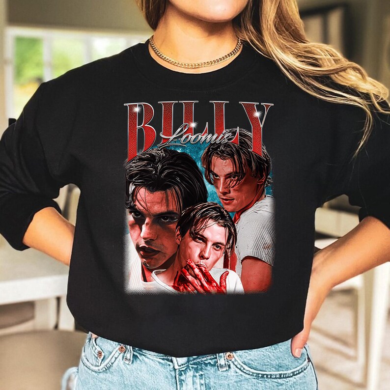 Puede incluir: Sudadera negra con un gr&aacute;fico de tres im&aacute;genes de un hombre y el texto "BILLY Loomis" en rojo y blanco. La sudadera tiene mangas largas. El gr&aacute;fico tiene un estilo vintage.