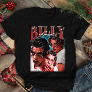 Puede incluir: Camiseta negra con un gr&aacute;fico de tres im&aacute;genes de un hombre y el texto "BILLY LOOMIS" en rojo y blanco. El gr&aacute;fico tiene un aspecto vintage y desgastado.
