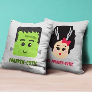 May include: Two white pillowcases with a green Frankenstein and a black-haired bride with a red bow. The pillowcases have the text "Franken-Cutie" and "Mrs. Franken-Cutie" printed on them.