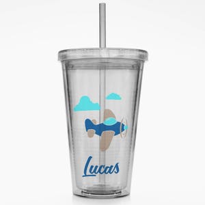 May include: A clear plastic tumbler with a straw, featuring a blue aeroplane with brown accents flying above blue clouds. The tumbler has the name "Lucas" printed on the bottom.