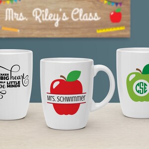 Puede incluir: Tres tazas de cer&aacute;mica blanca con diferentes dise&ntilde;os. La primera taza tiene texto negro que dice "Se necesita un gran coraz&oacute;n para ayudar a los peque&ntilde;os a moldear las mentes". La segunda taza tiene una manzana roja con una hoja verde y una pancarta negra que dice "Mrs. Schwimmer". La tercera taza tiene una manzana verde con una hoja verde y un c&iacute;rculo blanco con las letras "CSE" dentro.
