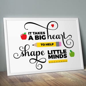Puede incluir: Impresi&oacute;n enmarcada en blanco con texto negro que dice "Se necesita un gran coraz&oacute;n para ayudar a moldear las mentes peque&ntilde;as". La impresi&oacute;n presenta una manzana roja, un l&aacute;piz amarillo, un coraz&oacute;n rojo y una manzana verde.