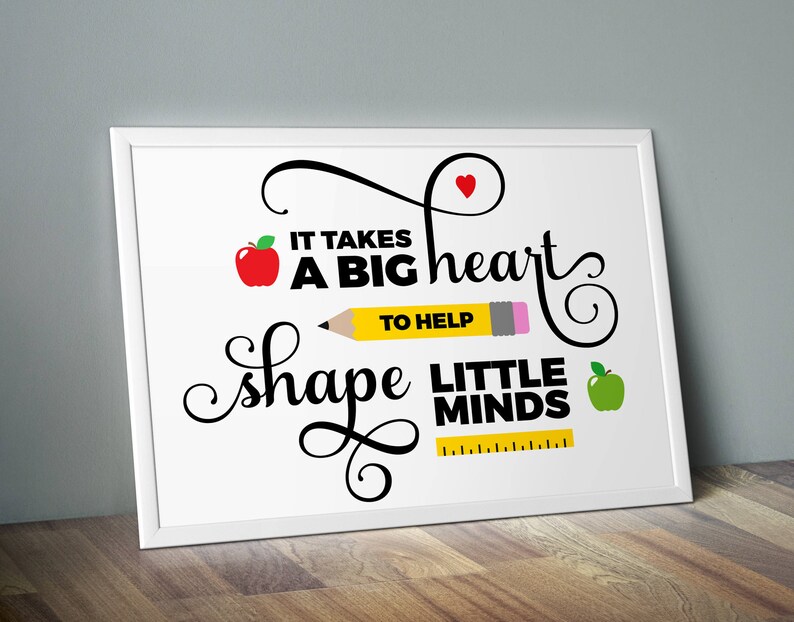 Puede incluir: Impresi&oacute;n enmarcada en blanco con texto negro que dice "Se necesita un gran coraz&oacute;n para ayudar a moldear las mentes peque&ntilde;as". La impresi&oacute;n presenta una manzana roja, un l&aacute;piz amarillo, un coraz&oacute;n rojo y una manzana verde.