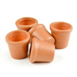 May include: Five terracotta flower pots of varying sizes, arranged on a white surface.