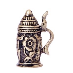 May include: A silver metal beer stein with a floral design. The stein has a lid and a handle.