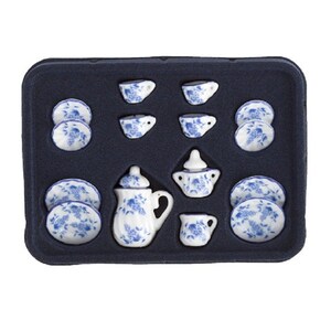 May include: A blue and white porcelain tea set in a black tray. The set includes a teapot, creamer, sugar bowl, four cups, and four saucers.