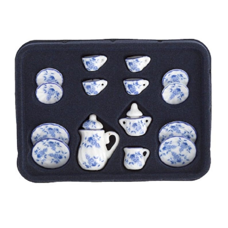 May include: A blue and white porcelain tea set in a black tray. The set includes a teapot, creamer, sugar bowl, four cups, and four saucers.