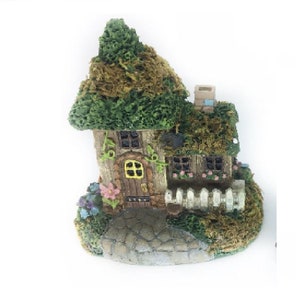 Miniaturowy domek wiejski pokryty mchem, domek terrarium z białym płotem, domek wróżek