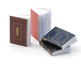 May include: Miniature books with detailed covers. One book has a brown cover with a gold rectangle, another has a red cover, and two are stacked with blue and black covers. The blue book reads "Paradise Lost".