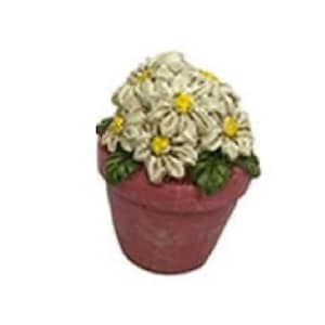 May include: A small pink ceramic flower pot with white flowers and green leaves.