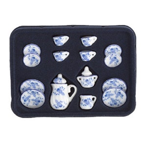 May include: A blue and white porcelain tea set in a black tray. The set includes a teapot, creamer, sugar bowl, four cups, and four saucers.
