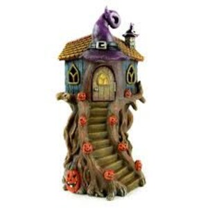 May include: A Halloween-themed fairy house with a purple witch hat, a brown wooden door, and a staircase leading up to the house. The house is perched on a tree trunk with carved pumpkin faces.