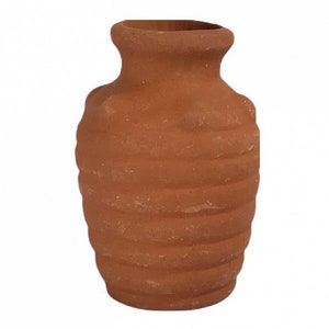 Könnte beinhalten: Eine kleine, terracottafarbene Vase mit geripptem Design. Die Vase ist hellbraun und hat eine abgerundete Form.