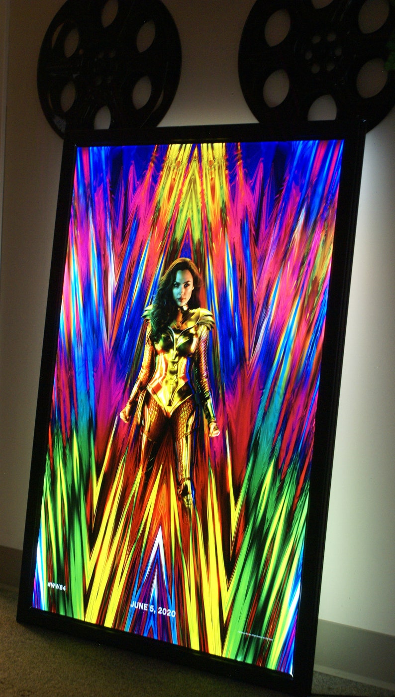May include: A movie poster for Wonder Woman 1984 featuring Wonder Woman in her golden armor standing in front of a colorful, abstract background. The text "JUNE 5, 2020" is at the bottom of the poster.