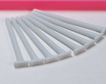 May include: A set of ten white plastic cable ties with a T-shaped head. The ties are arranged in a fan shape.