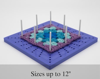 May include: A purple and blue crochet square is being blocked on a blue plastic crochet blocking board with white plastic pins. Sizes up to 12 inches.