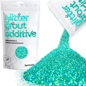 Peut inclure: Un sachet blanc avec le texte "glitter grout additive" et "adds sparkle to kitchen and bathrooms" imprimé dessus. Le sachet est ouvert et verse de la paillettes turquoise.