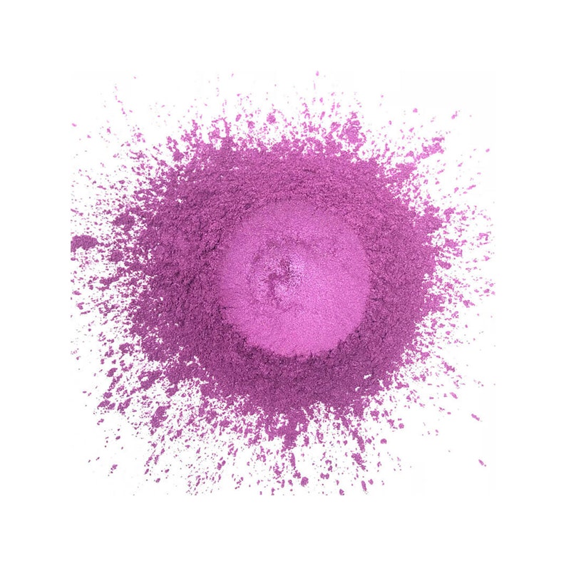 Pu&ograve; includere: Un mucchio circolare di polvere viola vibrante con un centro pi&ugrave; chiaro e iridescente. La polvere &egrave; sparsa sui bordi, creando un effetto schizzo sullo sfondo bianco. La consistenza appare fine e liscia.