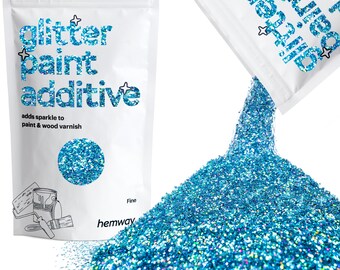 May include: A white bag of glitter paint additive with the text "glitter paint additive" in blue. The bag is pouring out a pile of fine, blue glitter. The text "adds sparkle to paint & wood varnish" is also visible.