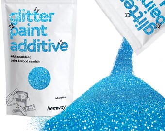 May include: A white bag of glitter paint additive with the text "glitter paint additive". The bag is next to a pile of bright blue glitter. The text "adds sparkle to paint & wood varnish" is also visible.