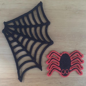 Op de afbeelding: Zwarte spinnenweb- en rode spinnen-Halloween-decoraties.