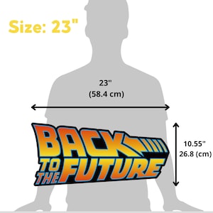 Op de afbeelding: Een Back to the Future-bord met de tekst "BACK TO THE FUTURE" in oranje en geel, met blauwe accenten. Het bord is 58,4 cm breed en 26,8 cm hoog.