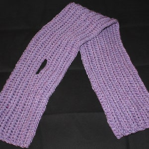 May include: A lavender-colored, hand-knitted scarf with a ribbed texture and a single opening. The scarf is made of soft yarn and is designed to be worn around the neck. The scarf is approximately 60 inches long.