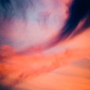 May include: A vibrant sunset sky with a mix of pink, orange, and purple clouds. The clouds are wispy and create a soft, ethereal effect.