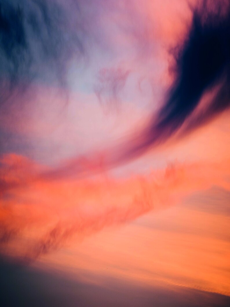 May include: A vibrant sunset sky with a mix of pink, orange, and purple clouds. The clouds are wispy and create a soft, ethereal effect.