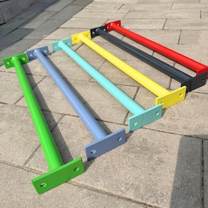 Może przedstawiać: Kolekcja kolorowych drążków do podciągania montowanych na ścianie. Każdy drążek jest w innym kolorze, w tym zielonym, niebieskim, turkusowym, żółtym, szarym i czerwonym. Drążki są wykonane z metalu i mają prostokątną płytę montażową na każdym końcu.