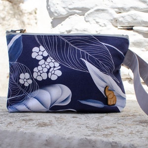 Muñequera tipo bolsa extra grande. Confeccionado en tela Canvas de Algodón. Decorado con hojas azules.